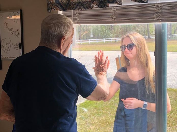 Woman shares engagement news through care facility window