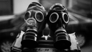 Couple pose with gas masks and 'dead' guests for wedding photos